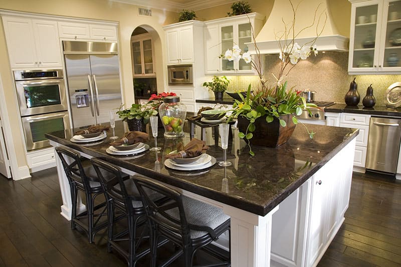 Dine And Wine On A Marble Top Island In A Square Spacious Kitchen With A Hardwood Floor