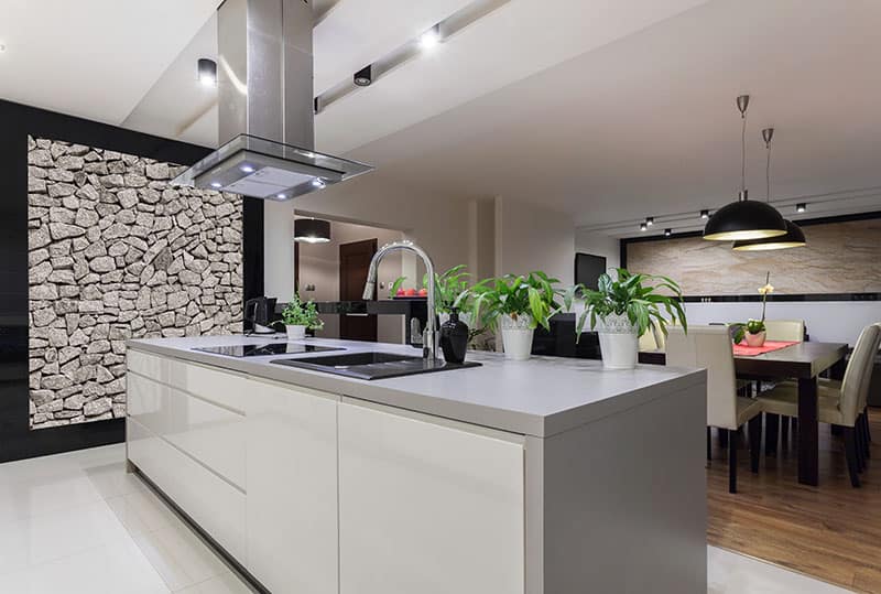 Large Brown Triangle Island In A Large Kitchen With Stone Wall