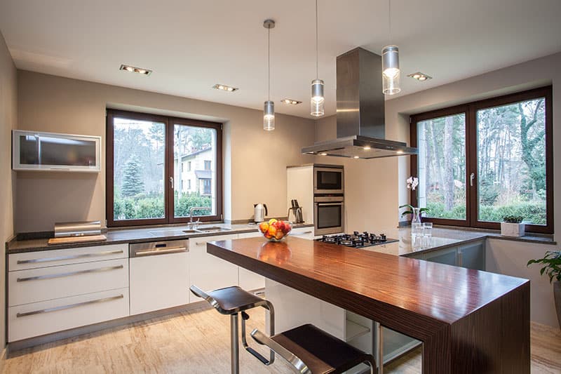 Long Wooden Kitchen Island In A Travertine House Horizontal View Of Kitchen