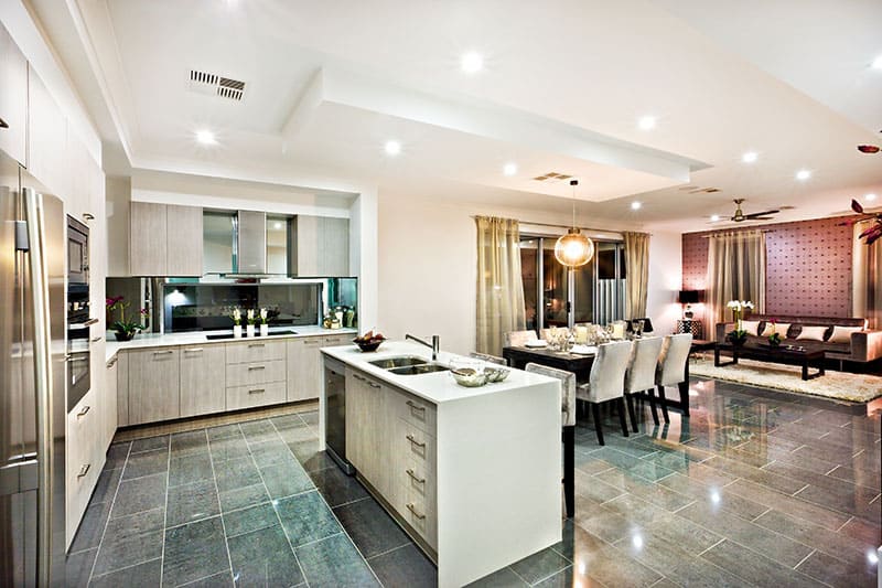 Pure White Island In A Modern And Shiny Kitchen With Dining And Living Area On The Reflective Tiles
