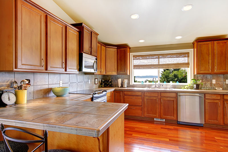 Dark Stained Hardwood Floor Contrasting The Ceiling While Maintaining A Surprising Consistency With The Cabinets And Wall Finish