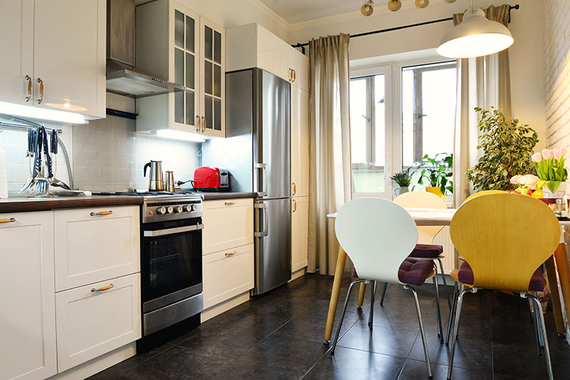 Dark Stone Floor Creates A Dark Shade And Blends In With The Cooker And Refrigerator