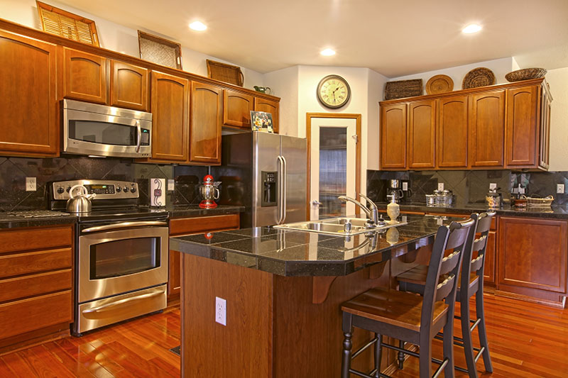 Kitchen Magnified By Dark Golden Cherry Cabinets And A Matching Hardwood Floor