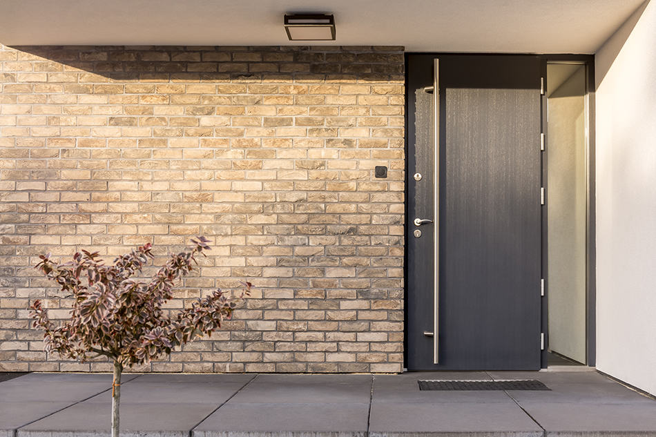 Black door with red brick exterior