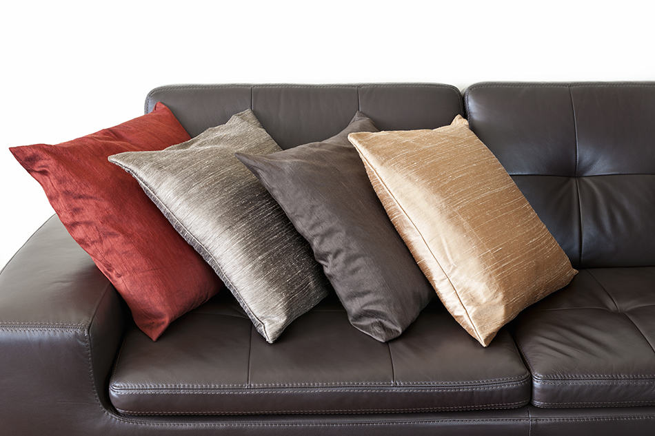 gray chunky knit throw on brown leather sofa