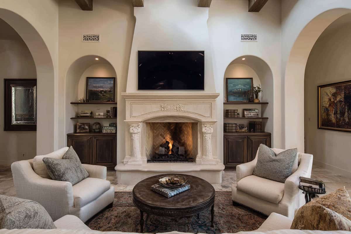 Arched Built Ins Around Central Fireplace With TV in One Arch