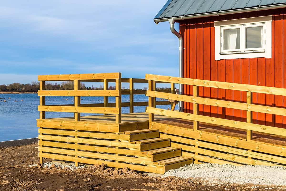 A Water Front Porch with Horizontal Plank Railings