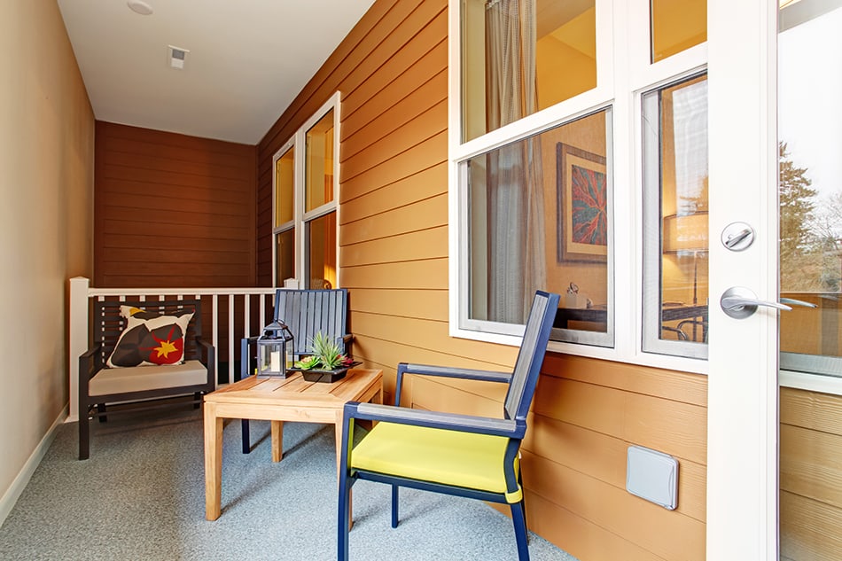 Narrow Screened Porch with Wooden Table and Chairs