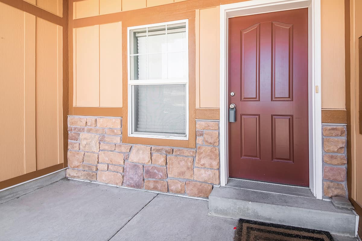 Burgundy front door and light tan House