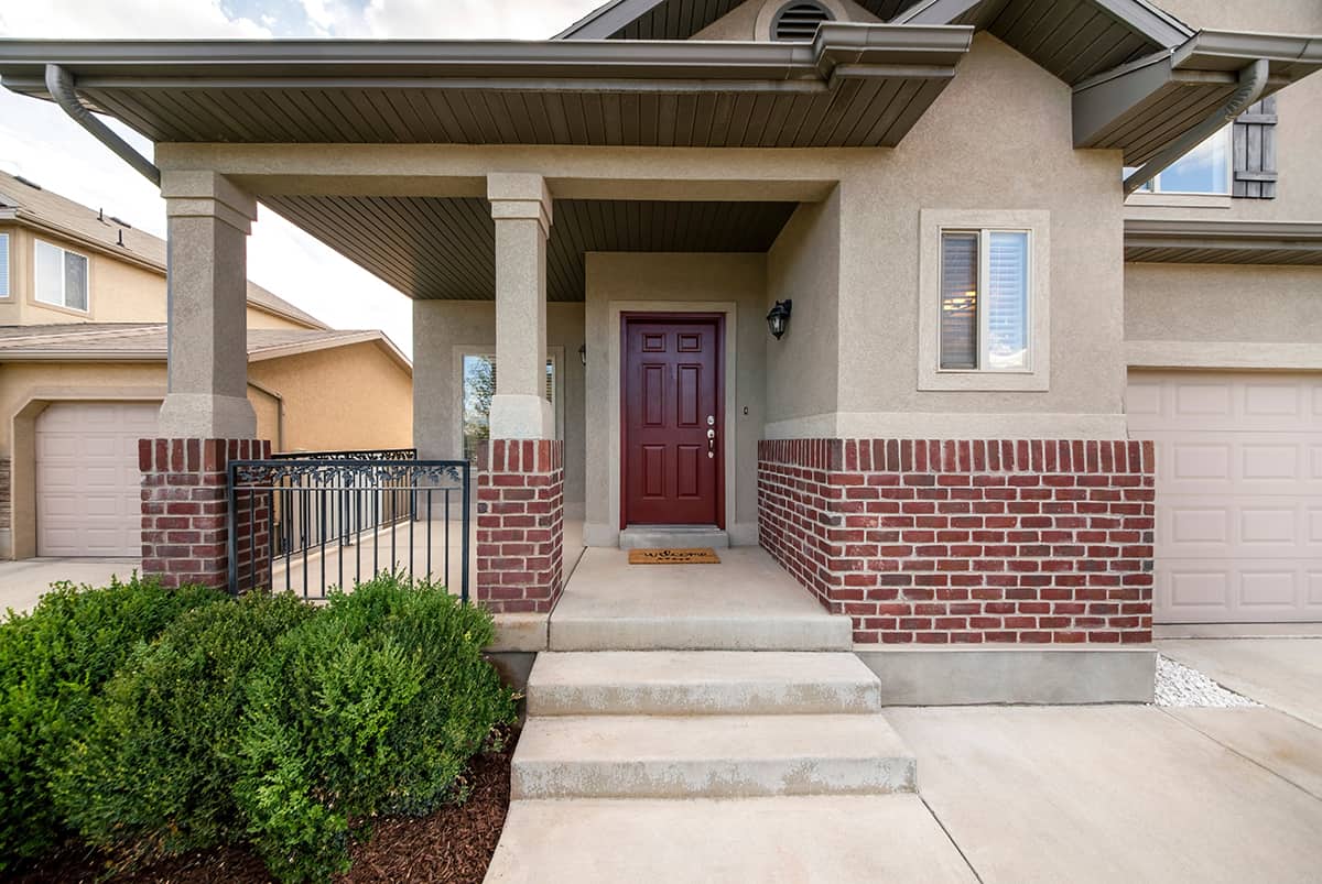 Burgundy front door with a warm tan house