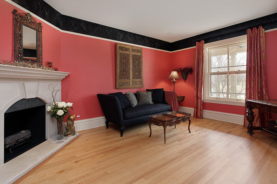 Black Furniture and Light Red Wall Contrasting with Light Hardwood