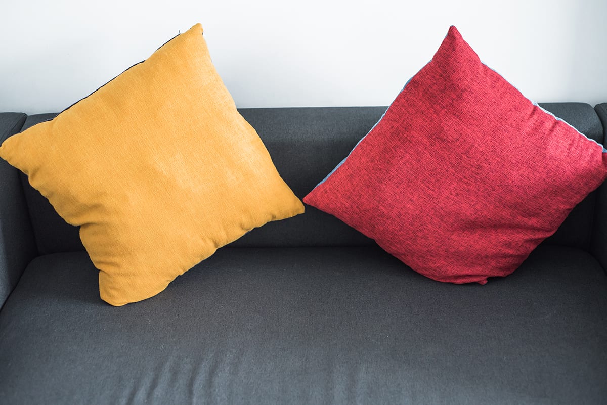 Warm-Colored Pillows and Black Leather Couch