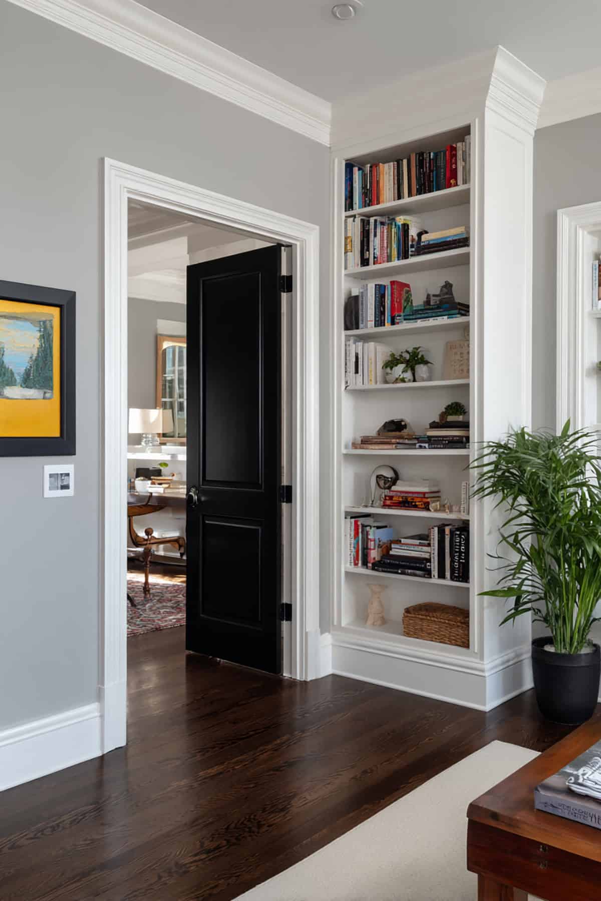 Black Door Framed by White Built In Shelving