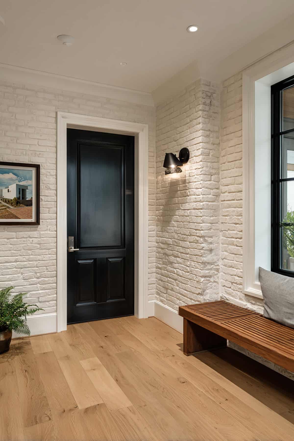 Black Door with White Trim and a White Brick Accent Wall Nearby