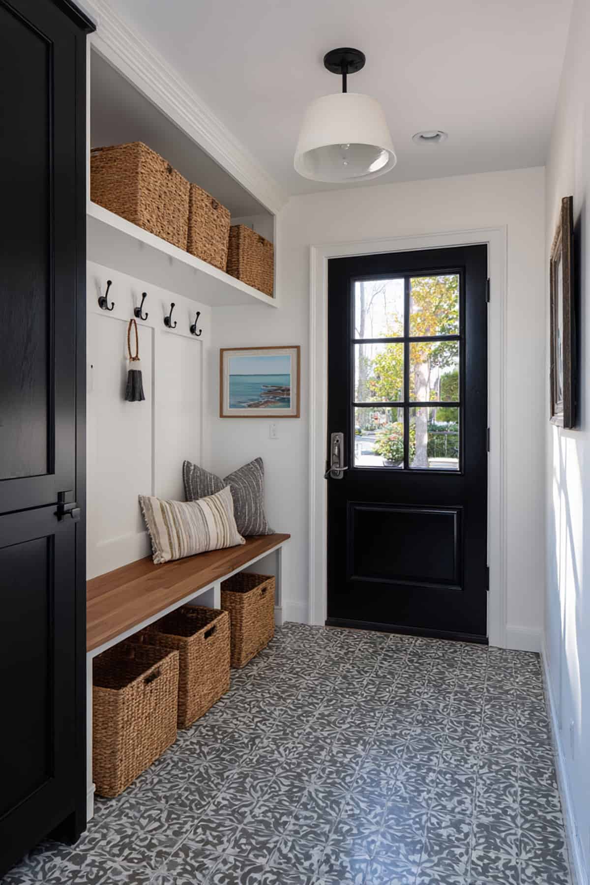 Black Door with White Trim in a Bright Mudroom with Patterned Floor Tile