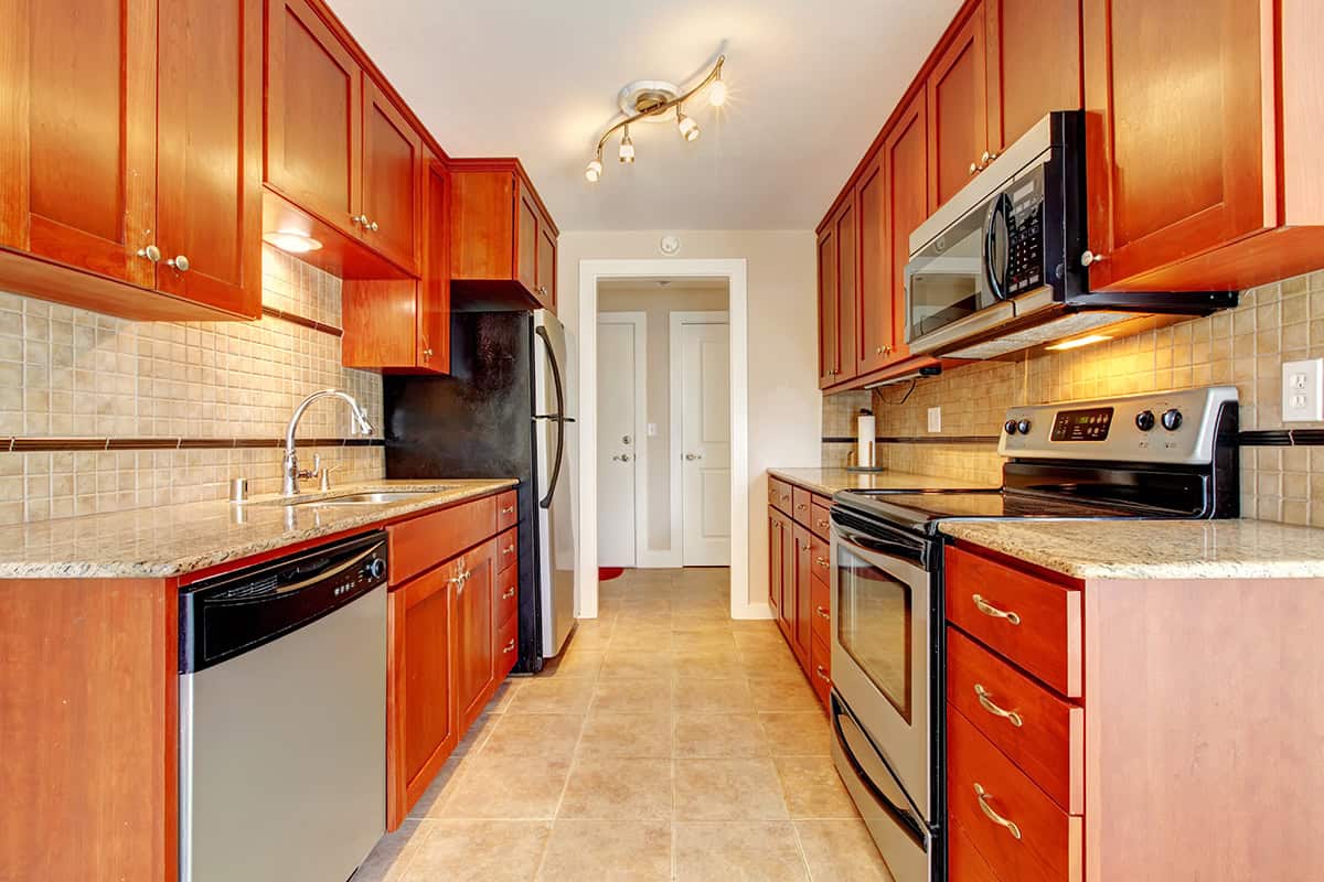 Cherry Wood Galley Kitchen With Stainless Steel Accents