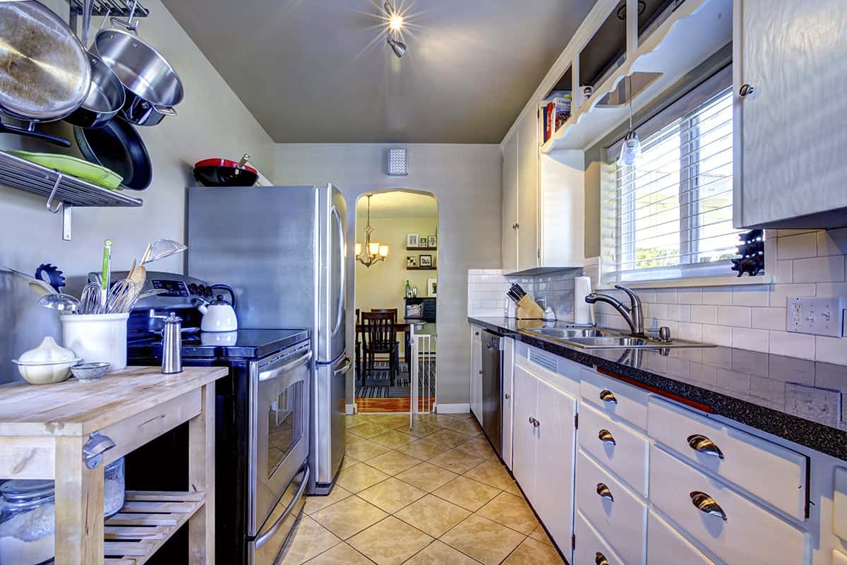 Galley Kitchen With Open Shelves and Stainless Steel Appliances