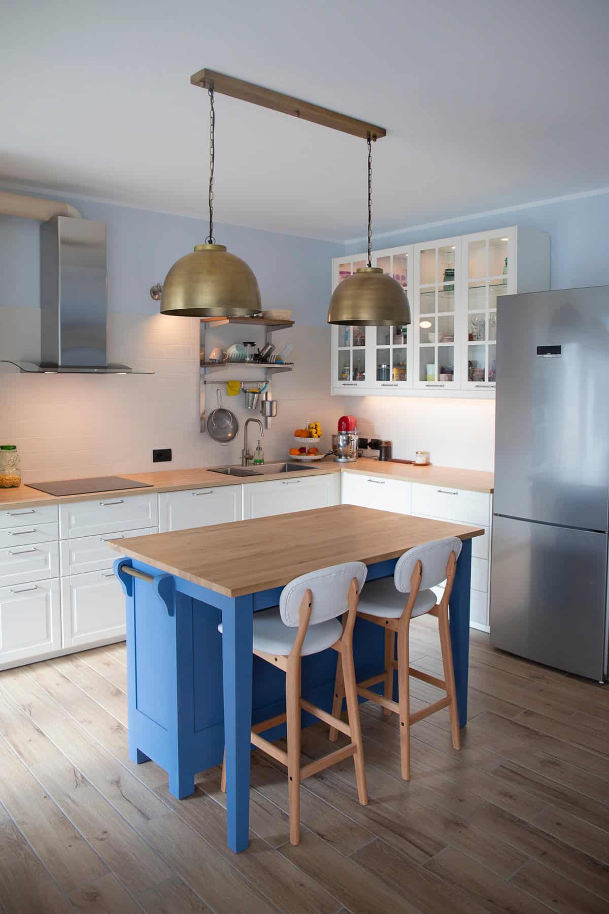 Bright Kitchen with Blue Island and Brass Pendant Lights