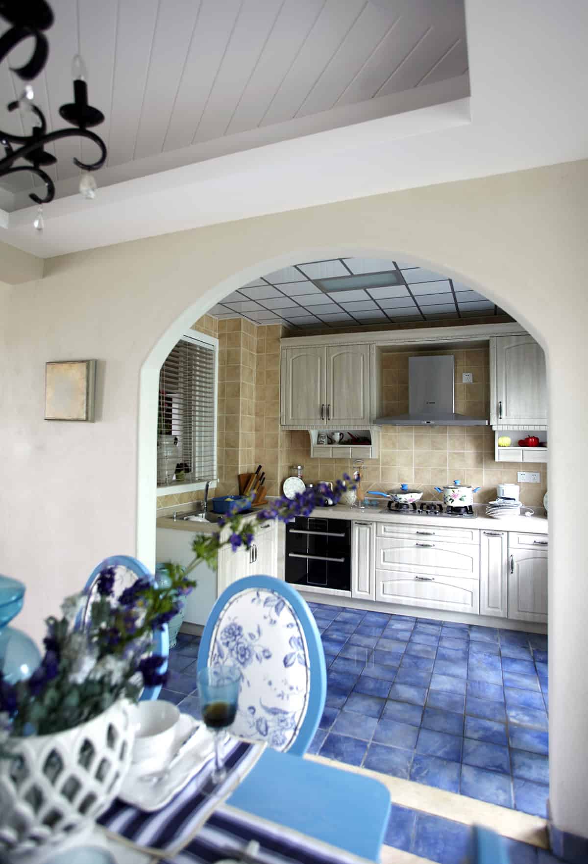 Mediterranean Style Kitchen with Blue Cabinets and Warm Tiles