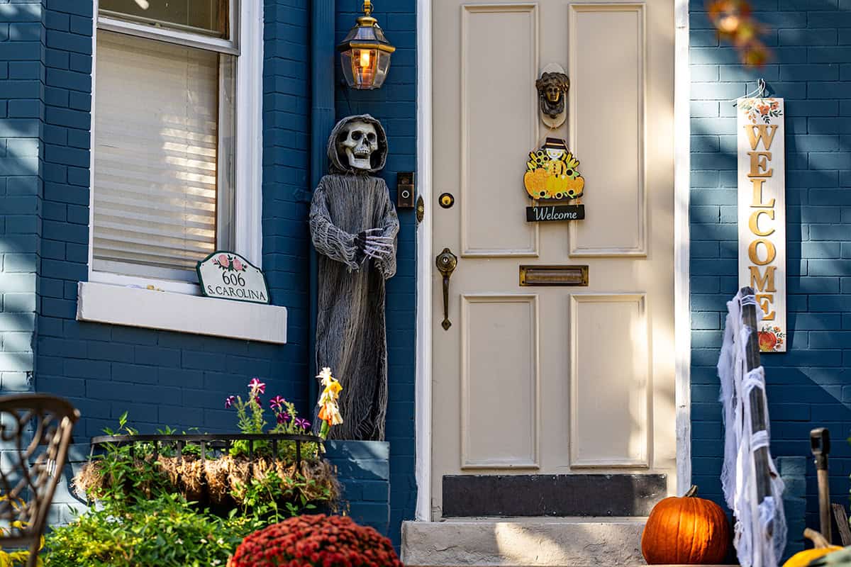 Skeleton Greeting Beside a Pale Door