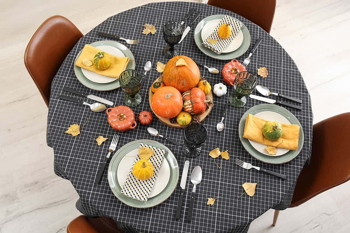 A Checkered Tablecloth With Pumpkins Scattered Like Confetti