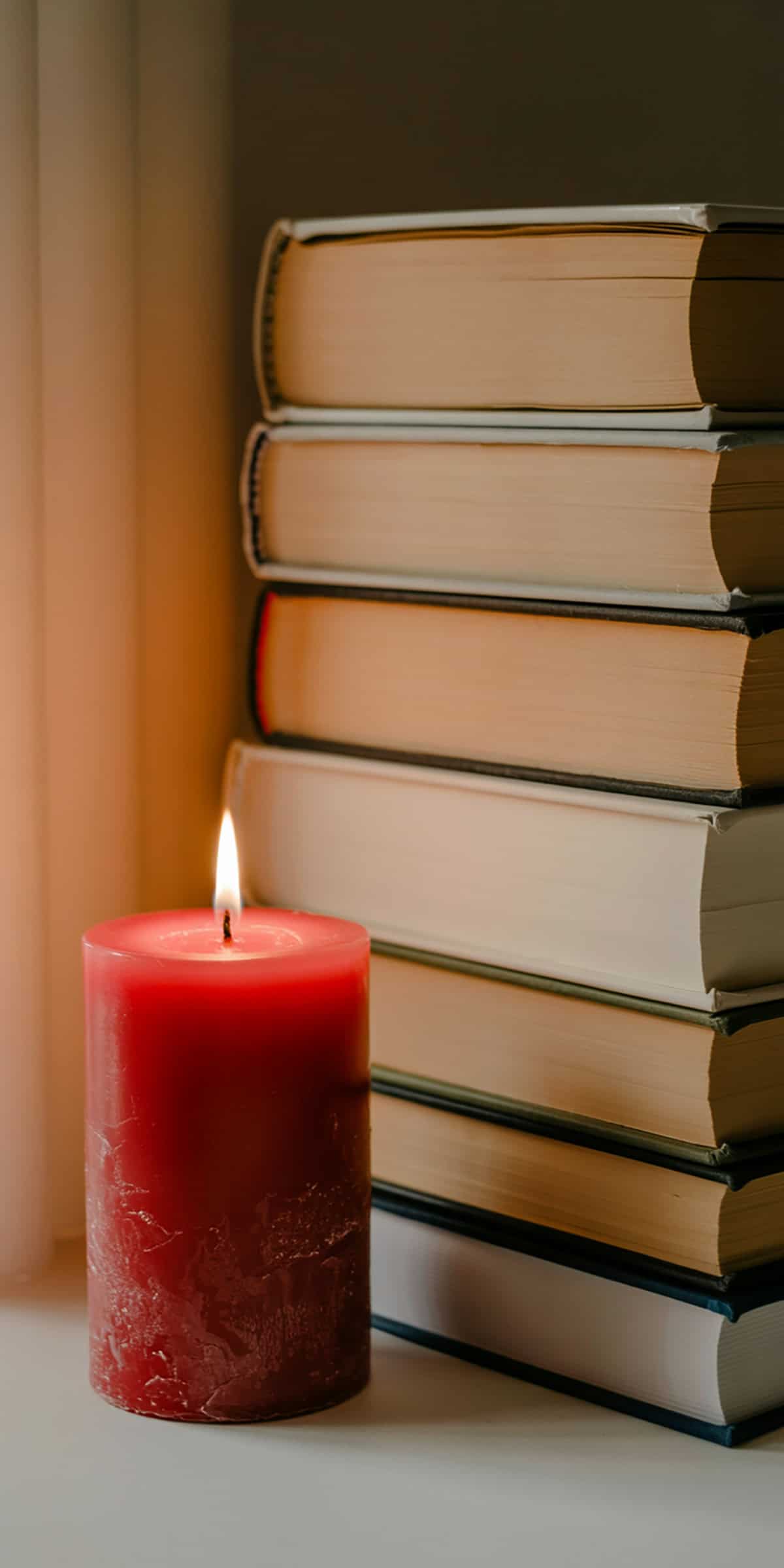 Red Candle Beside Book Stack