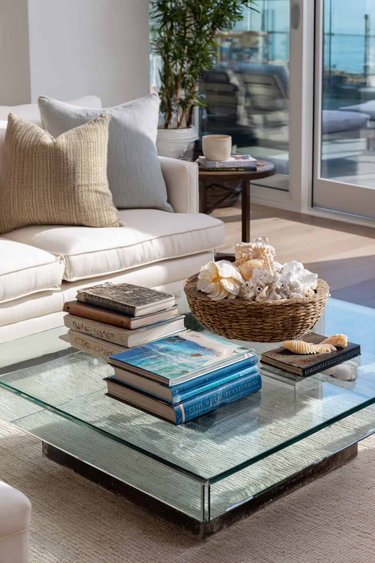 Glass Coffee Table Styled with Coastal Books and Decorative Objects
