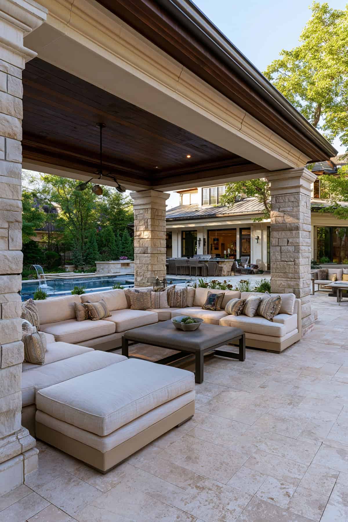 Covered Patio With Stone Columns And Sectional Sofa