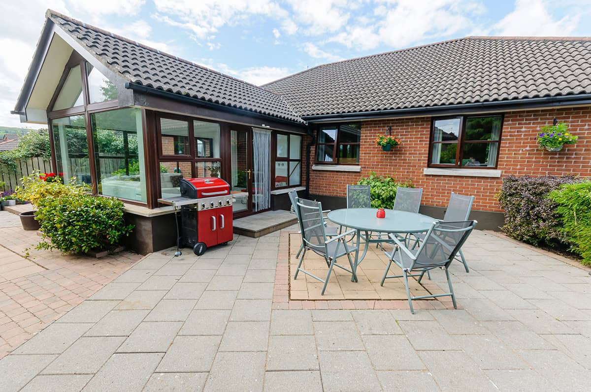 Modern Bungalow Exterior With Backyard Dining Area and Sunroom