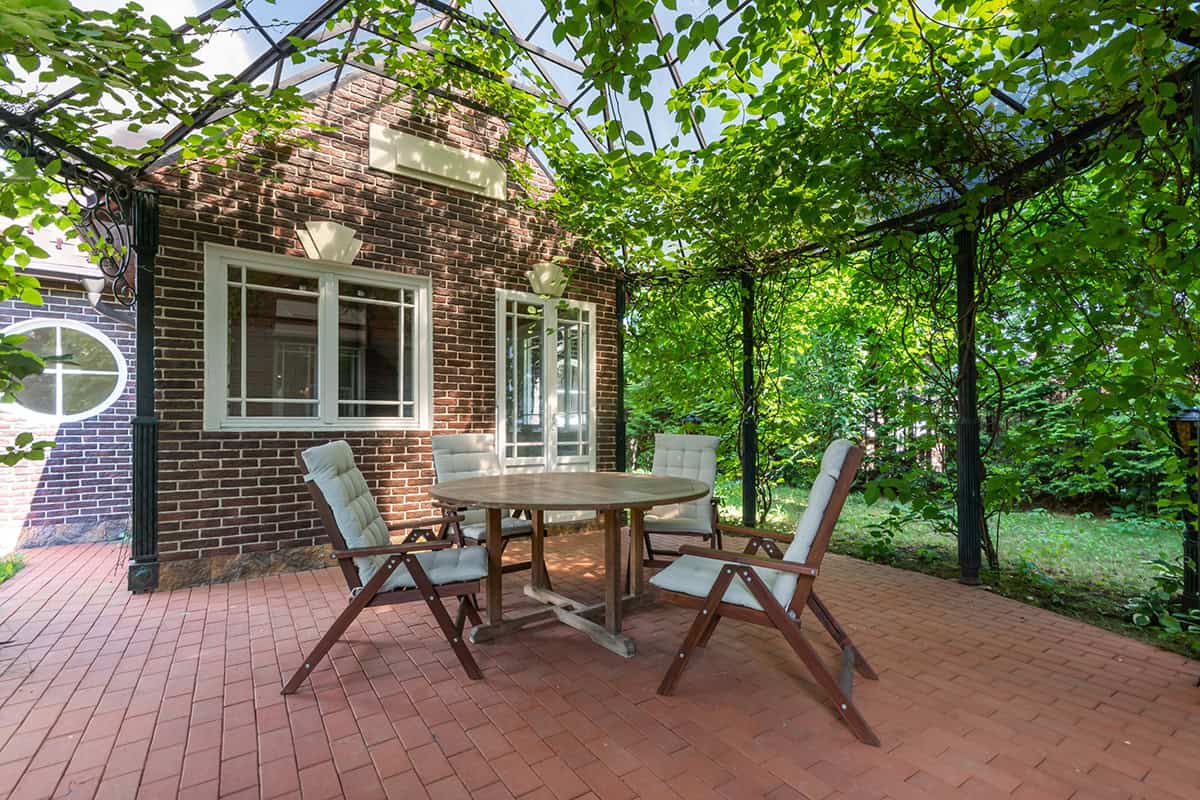 Vine Covered Patio With Outdoor Table And Chairs