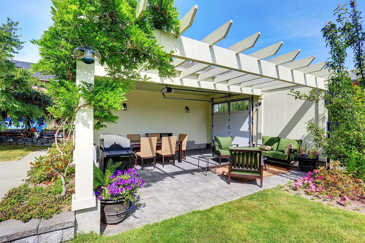 White Pergola Covered Patio With Garden Seating