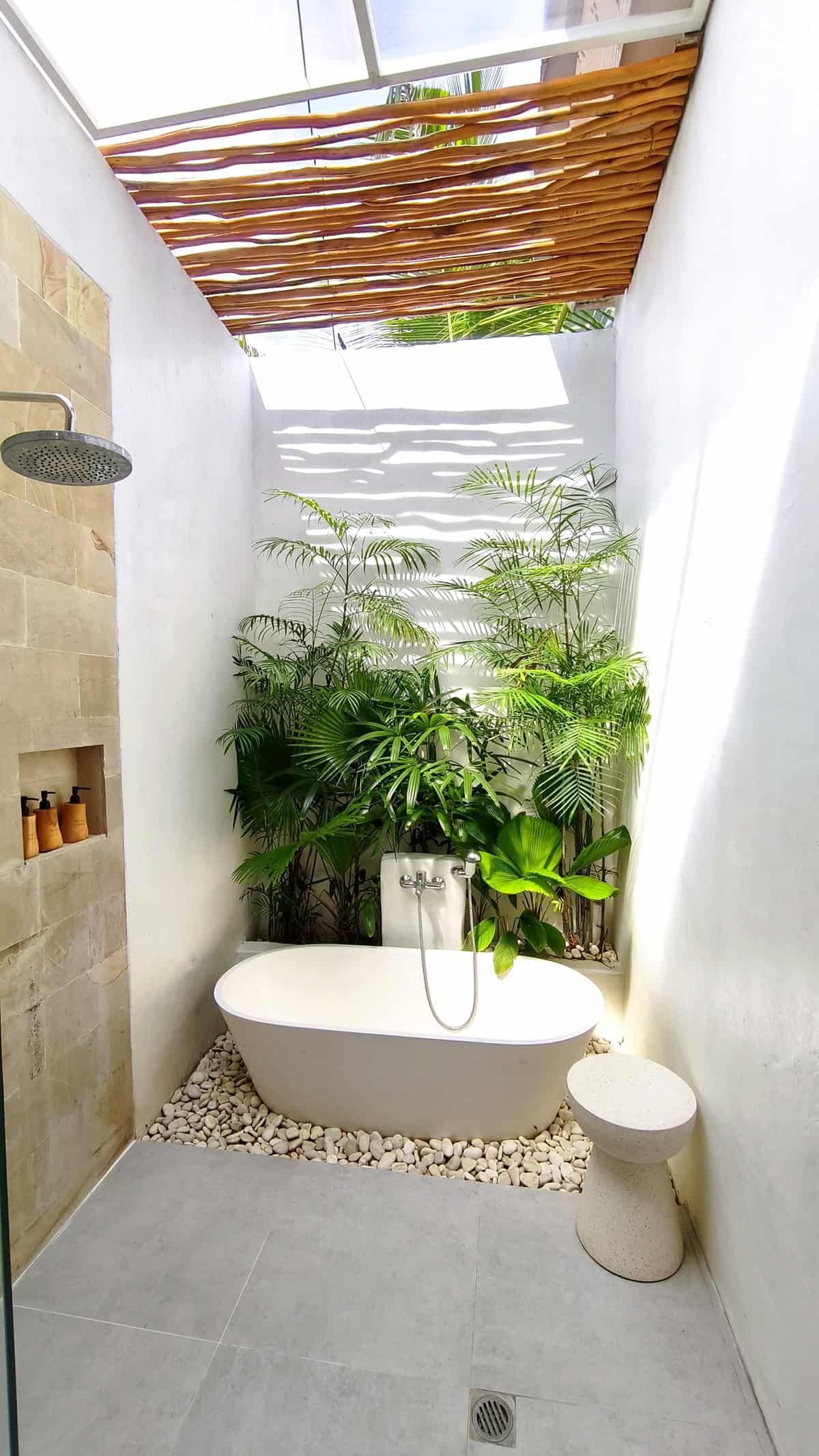 Tropical White Open Air Bathroom with Freestanding Bathtub and Lush Indoor Plants