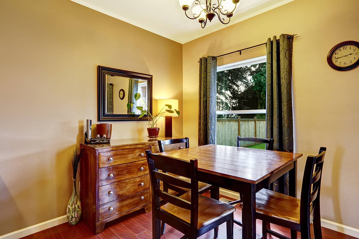 A Dark Framed Mirror with Warm Wood Furniture