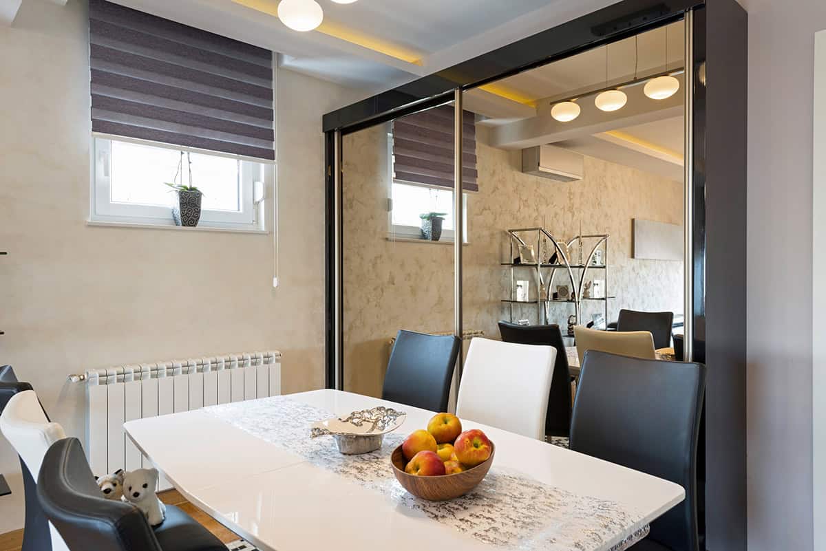 Mirrored Sliding Doors Behind the Dining Table