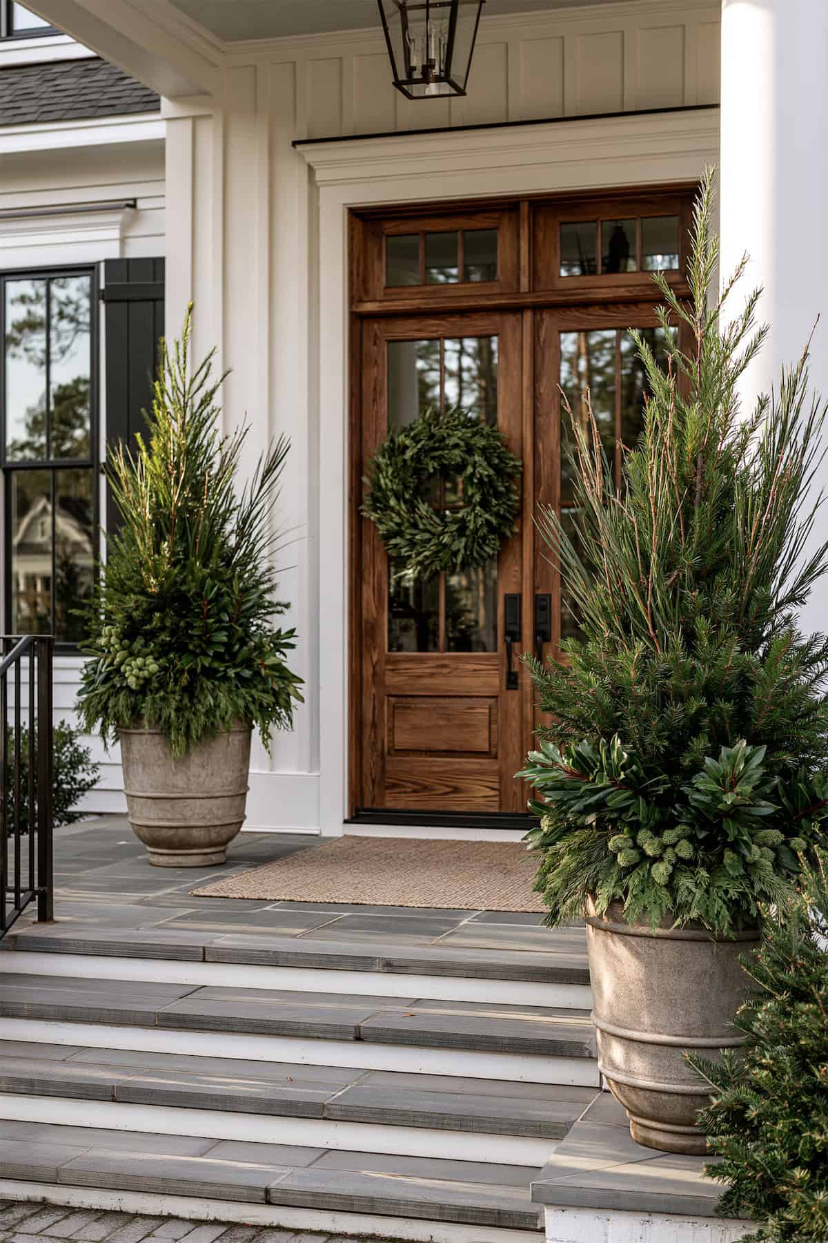 Tall Evergreen Urns Flank a Wood Door